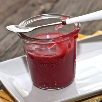 Jar filled with plum, pear and lavender baby food puree.
