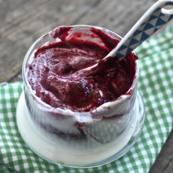 Small clear bowl filled with berry baby food puree swirled in with yogurt.