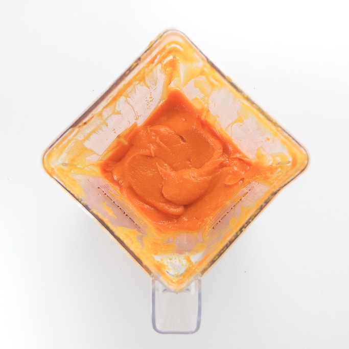 overhead shot of a blender filled with a creamy and smooth homemade carrot baby food puree
