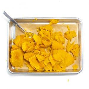 A baking sheet with chunks of roasted pumpkin without the skin.