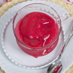 Clear jar filled with a cranberry baby puree.