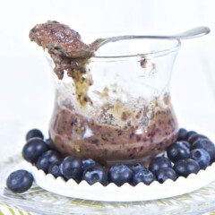 Image is of a clear cup with the chunky puree inside, with a spoon resting on top of the lid.