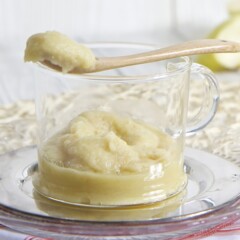 Glass bowl filled with homemade puree with spoon resting on top.