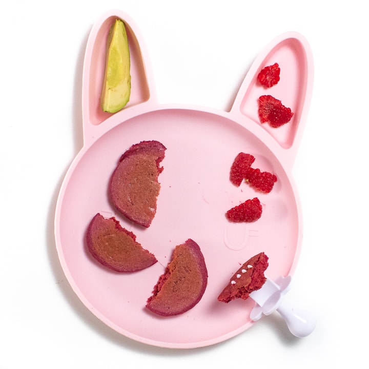 Pink bunny plate for baby or toddler filled with pink pancakes, raspberries and avocado.