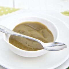 small bowl filled with the homemade puree with a spoon resting next to it filled with puree.