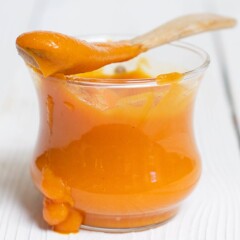 Image is of a glass bowl filled with smooth baby food puree.