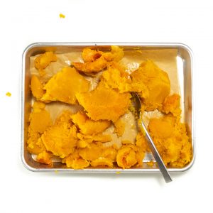 Chunks of roasted butternut squash with the skin off on a baking sheet.