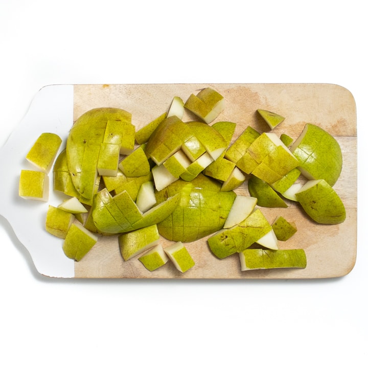 Cutting board with chopped pears.