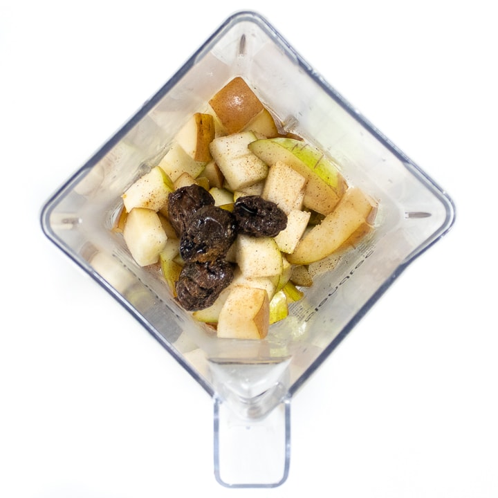 Blender with steamed pears, prunes and cloves ready to pureed.