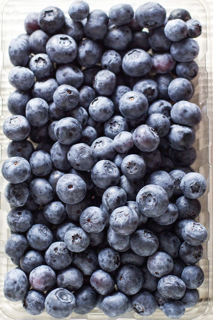 Tray of blueberries on a white background.