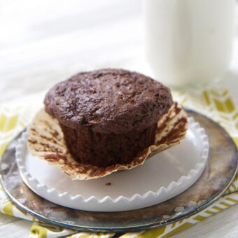 A chocolate pear whole wheat muffin on a white plate.