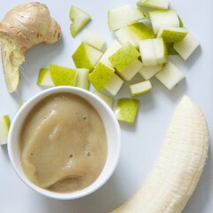 Spread of banana, chopped pear, ginger and a small bowl of baby food puree.