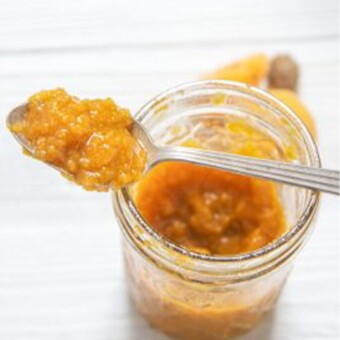 Apricot and clove jam on a spoon