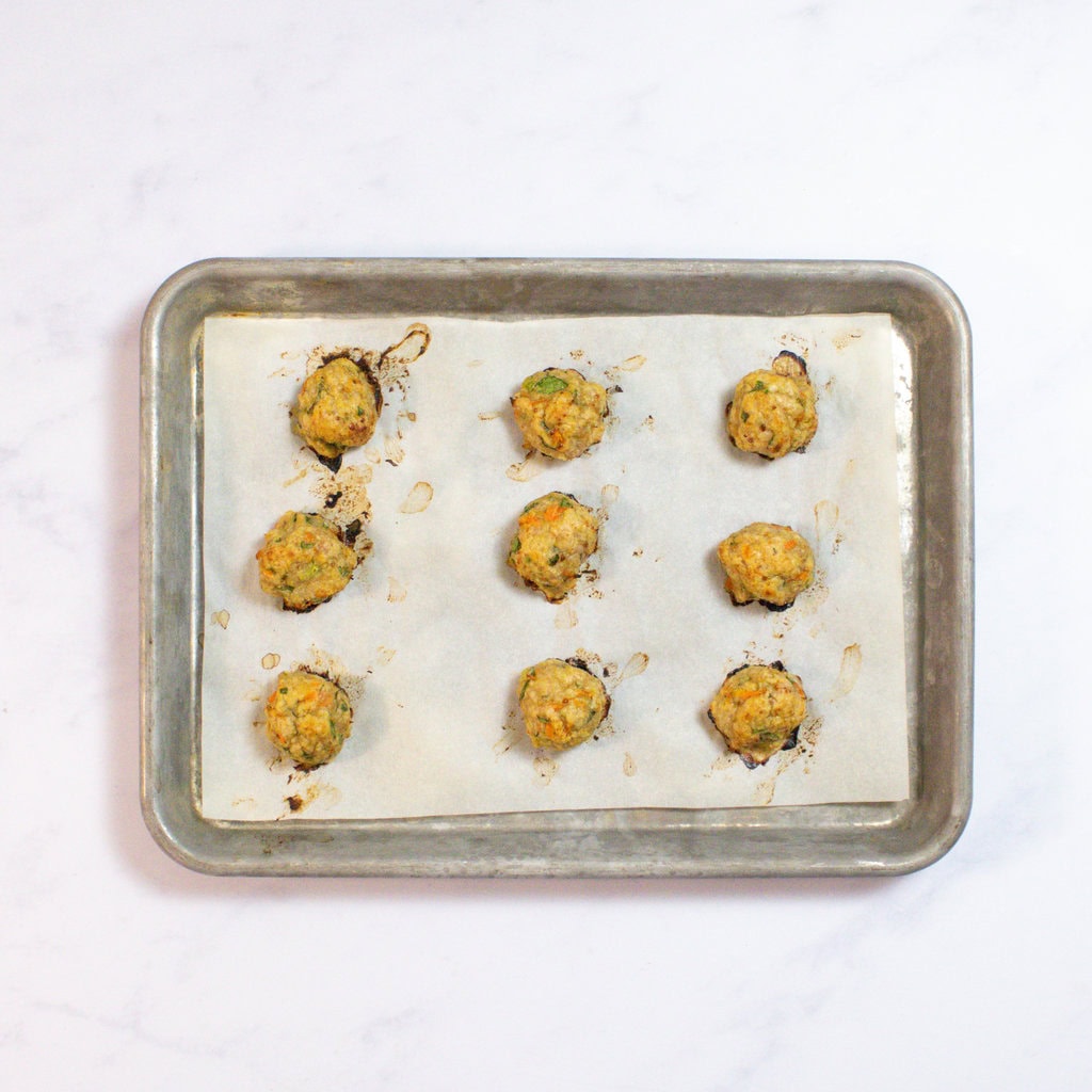 Baking tray on my kitchen counter with backed ground meatballs.