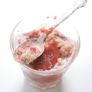 A small clear glass with strawberry oatmeal for baby and toddler inside.