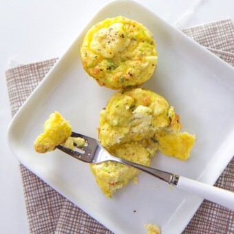 Kid friendly mini quiche with feta and pepper on a white plate.