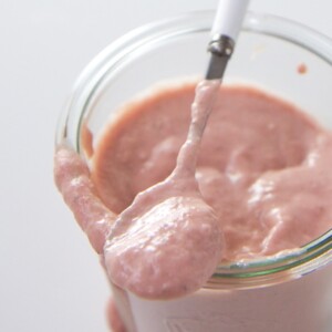 Clear jar filled with strawberry salmon baby food.