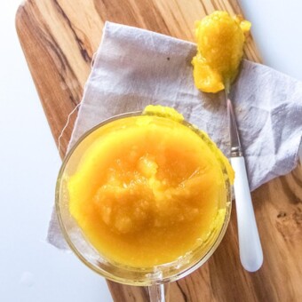 small glass bowl filled with pumpkin baby food puree.