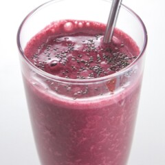 Cherry and beet toddler smoothie in a glass with a metal straw.
