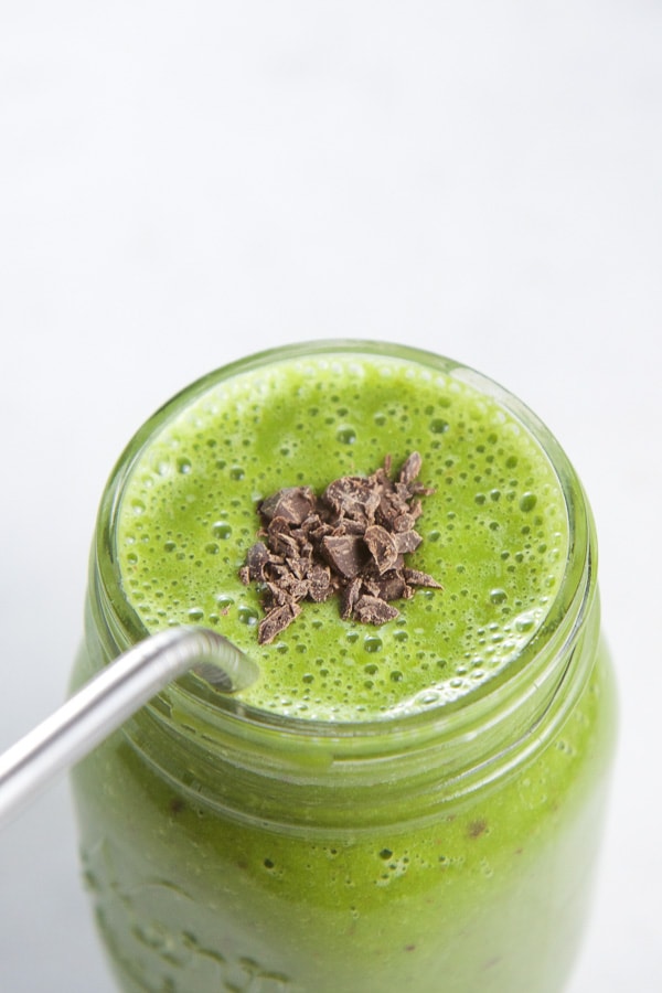 Healthy mint chocolate smoothie in a mason jar with a stainless steel straw.