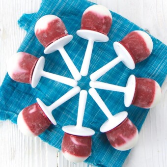 Hidden veggie beet popsicles in a circle on a blue napkin.