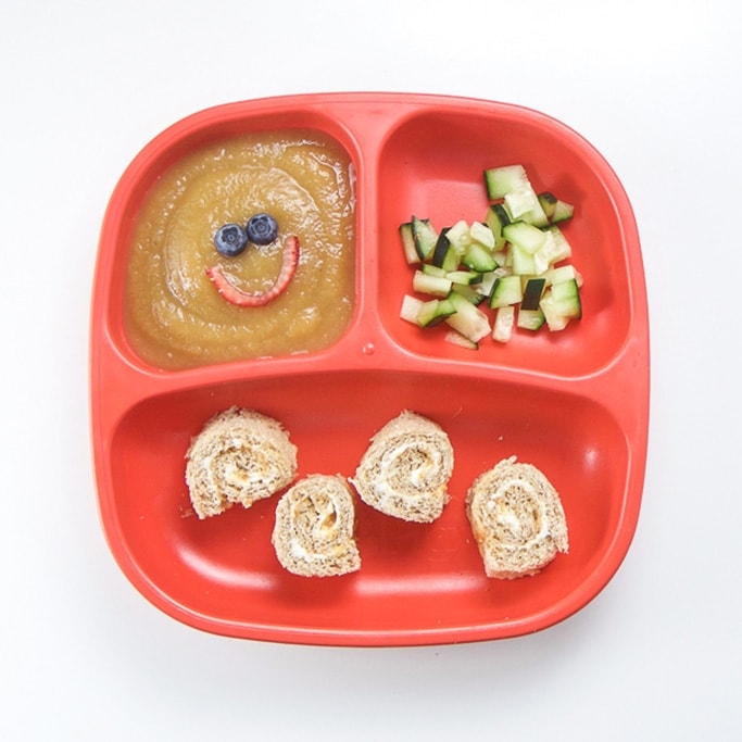 A healthy toddler lunch on a red plate.