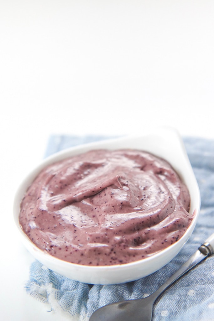 Small white bowl filled with blueberry banana avocado baby food puree.