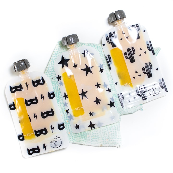 Reusable baby food pouches full of peach puree for baby.