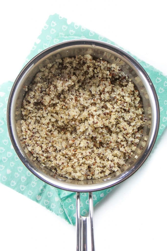 Silver saucepan filled with cooked quinoa.