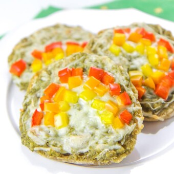 Three toddler rainbow pizzas on a white plate.