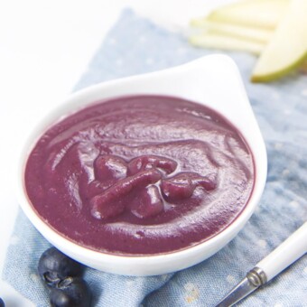 Pear and blueberry baby food puree in a small white bowl.