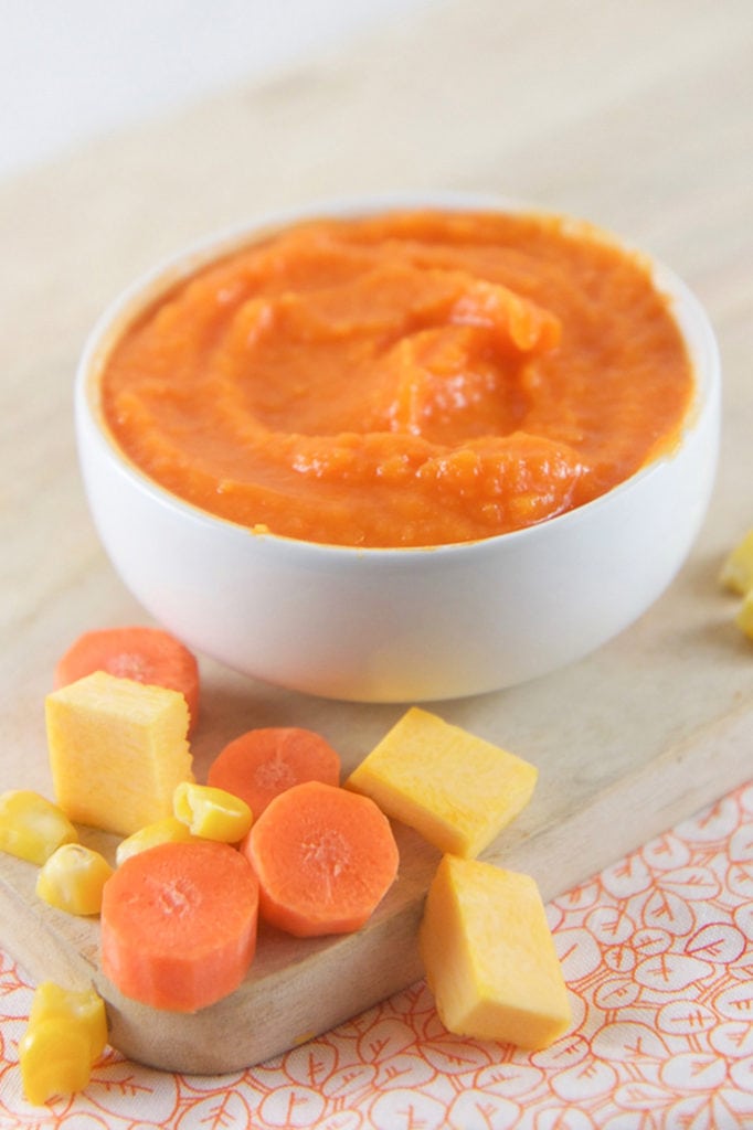 A small white bowl filled with a carrot pumpkin baby food puree. 