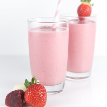 Two kid friendly pink smoothies on a white background.