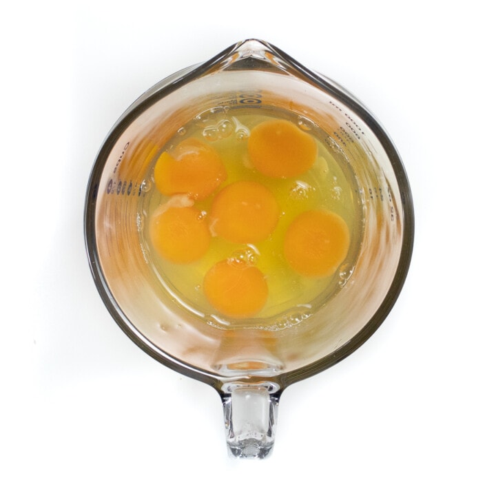 Big measuring cup filled with eggs.