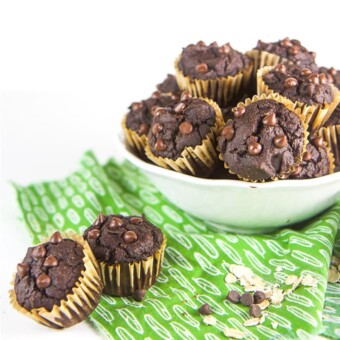 Allergy friendly pumpkin chocolate muffins for kids and toddlers in a white bowl with two muffins on the side.