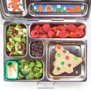 A silver lunch box filled with holiday themed foods for kids.