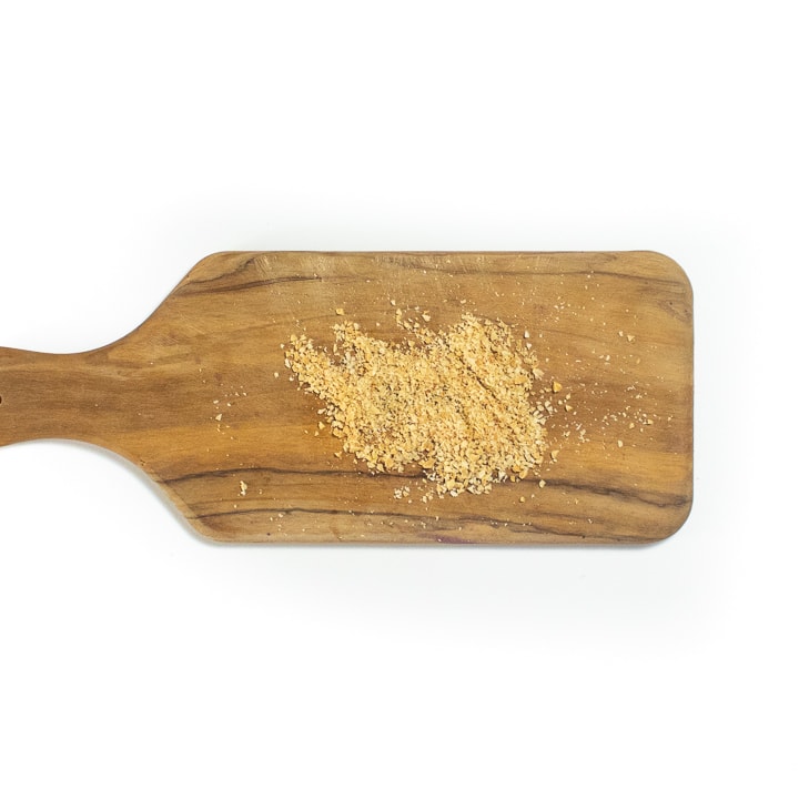 Cutting board with crushed peanuts.