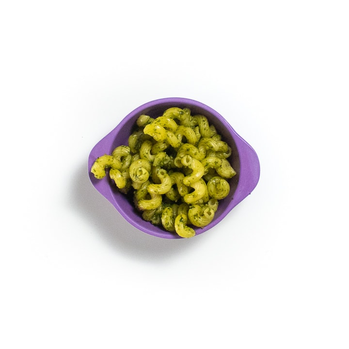 Purple baby bowl filled with pesto pasta.