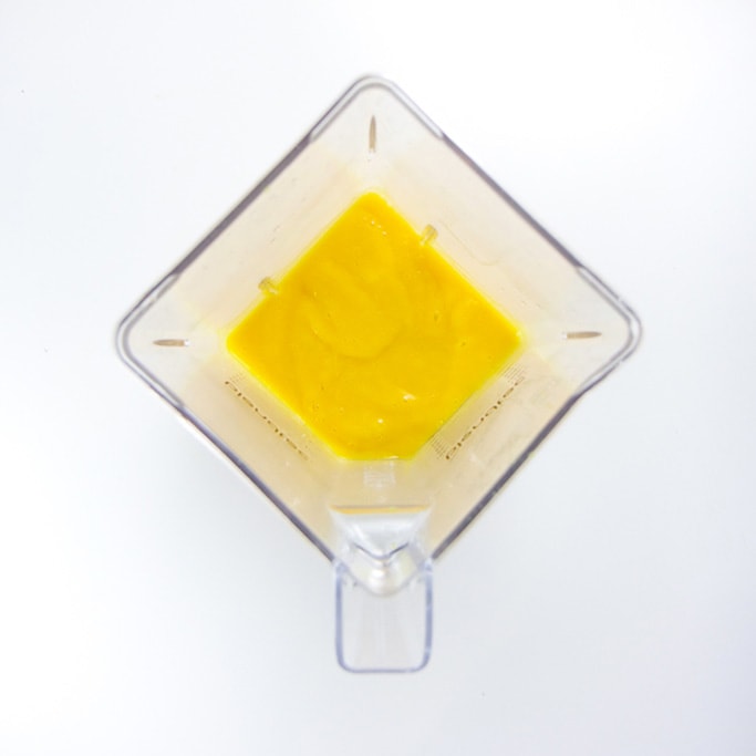overhead shot of a blender filled with a creamy mango baby food puree