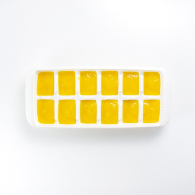 white freezer tray sitting on a white background filled with a creamy organic mango baby food recipe