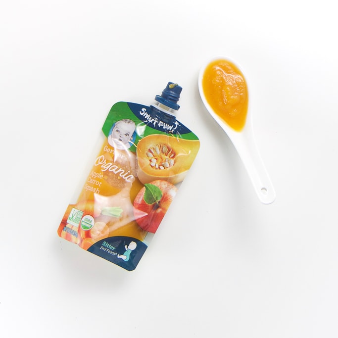 Gerber organic baby food brand pouch with a spoon filled with it's puree