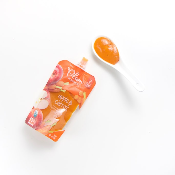 organic baby food brand pouch with a spoon filled with it's puree