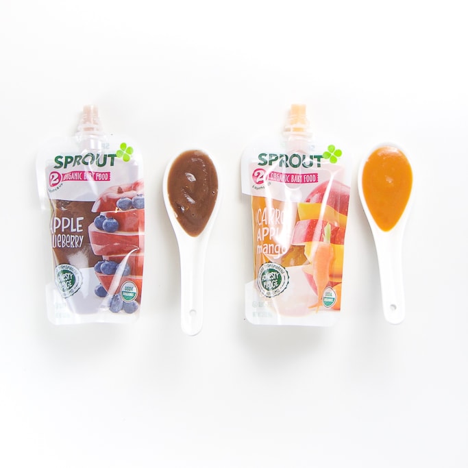 2 sprout baby food pouches with spoons next the them with puree inside.