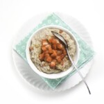 white bowl sitting on a teal napkin filled with quinoa cereal toped with strawberries.