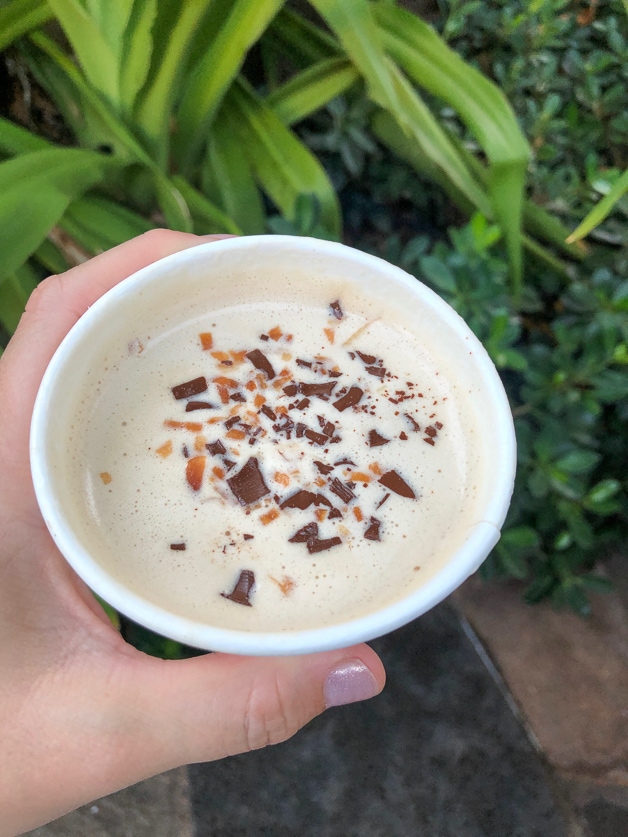 Coconut coffee in front of leafy palms - Disney Aulani. 