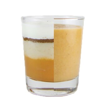 Clear cup half filled with ingredients for the puree and the other half of the cup is the homemade baby food puree.