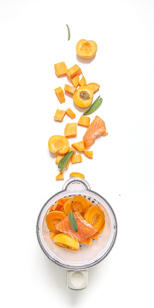 image is of a blender with produce scattered outside of it