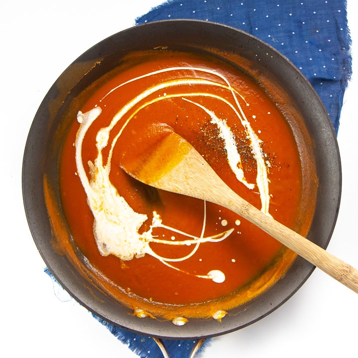 pumpkin sauce with a drizzle of cream in a skillet.