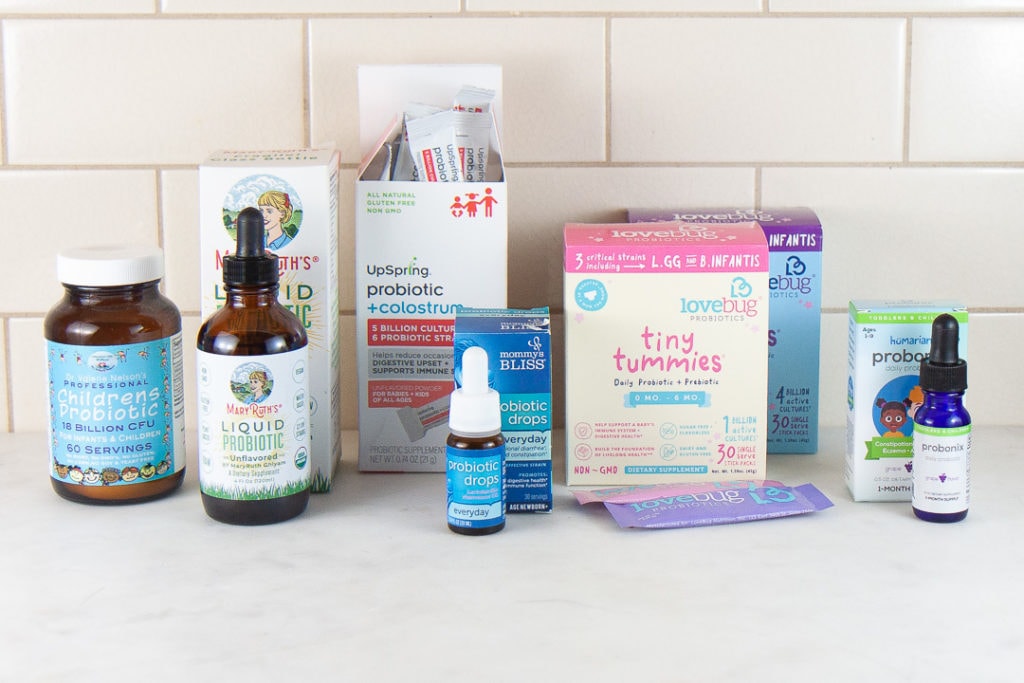 6 best probiotic brands for infants, baby and toddler, lined up in a row on a kitchen counter.