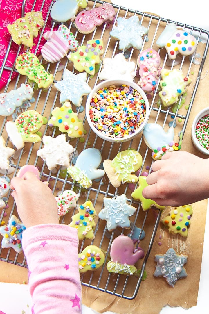 Kids hands decorating gluten free sugar cookies with dye-free sprinkles.